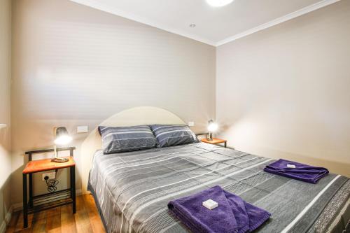 a bedroom with a bed with purple towels on it at Kalbarri Tudor Holiday Park in Kalbarri