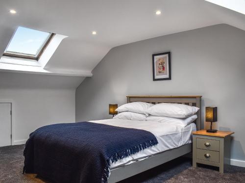 een slaapkamer met een groot bed en een dakraam bij Grey Gull in Whitby