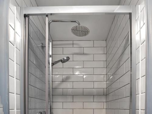 een douche in een badkamer met witte tegels bij Grey Gull in Whitby
