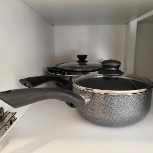 two pots and pans on a stove in a kitchen at Cozy & Drive Urban Suite by WL in Jelutong