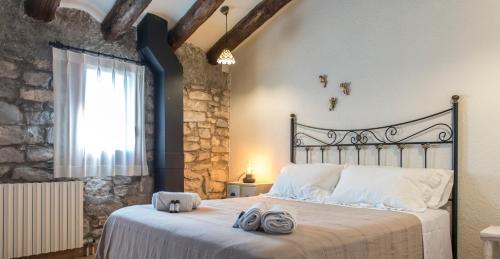 um quarto com uma cama grande e toalhas em La Botigueta de Bellmunt em Penellas