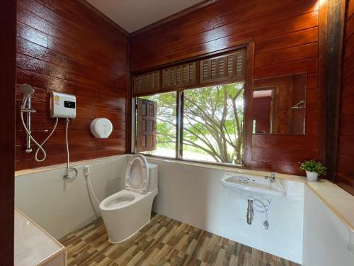 a bathroom with a toilet and a sink at อีสานบ้านเฮาฟาร์ม Esan Banhao Farm in Ban Om Ko