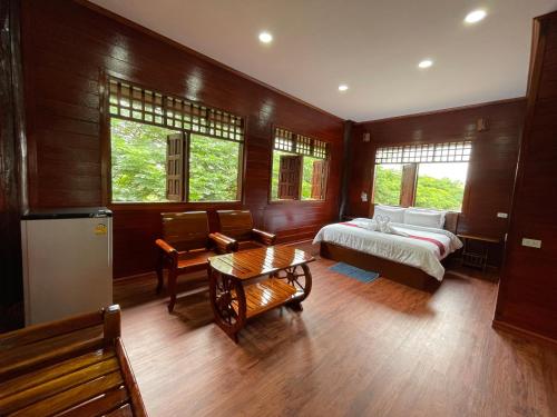 1 dormitorio con 1 cama y 1 mesa en อีสานบ้านเฮาฟาร์ม Esan Banhao Farm, en Ban Om Ko