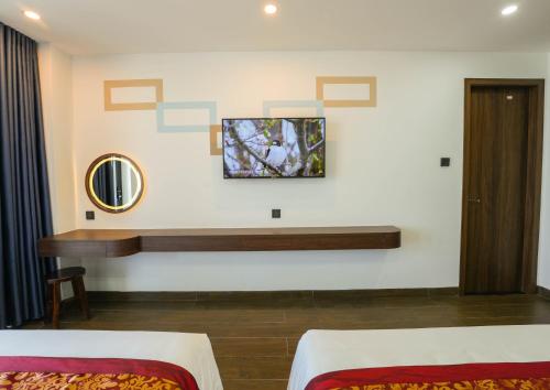 Pokój z 2 łóżkami, stołem i lustrem w obiekcie Gia Kiên Hotel w mieście Quy Nhơn