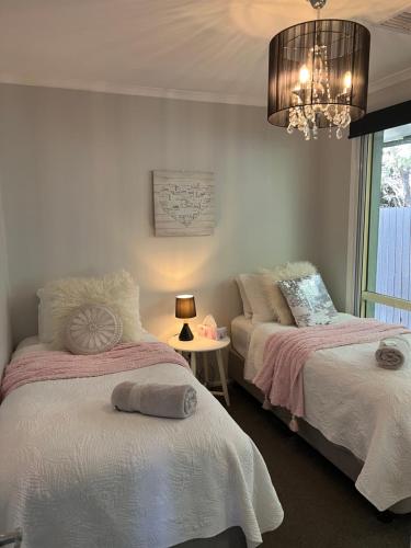 1 dormitorio con 2 camas y lámpara de araña en Belle in Bowral, en Bowral