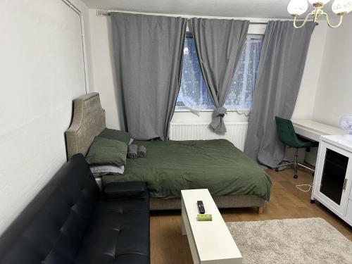 uma sala de estar com uma cama e um sofá em Great 5-Bed Wembley Home 25min from Central London em Londres