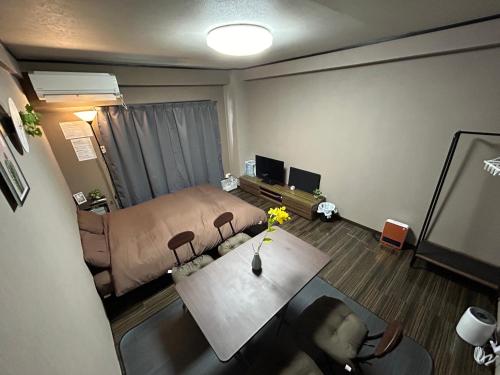 um quarto com uma cama, uma mesa e um sofá em Guest House GENESIS OF FREEDOM INN em Fukuoka