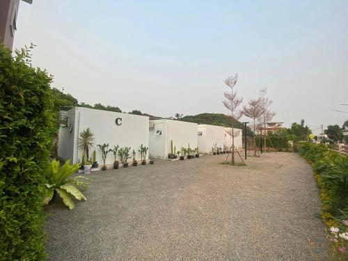 a building with a lot of plants in a yard at 65 hostel chiangmai in Chiang Mai