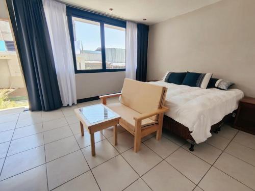 una camera con un letto e una sedia e una finestra di Habitacion privada Lamat I a San Pedro La Laguna