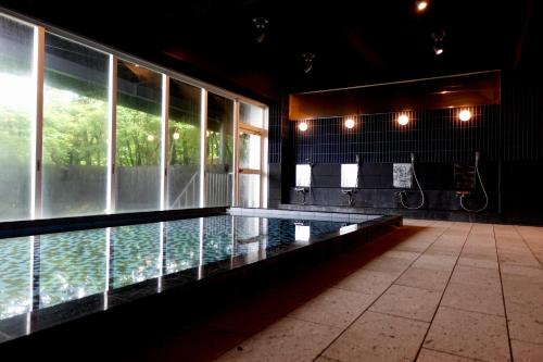 a swimming pool in the middle of a building at Resort Hotel RAKI House Nasu in Nasu