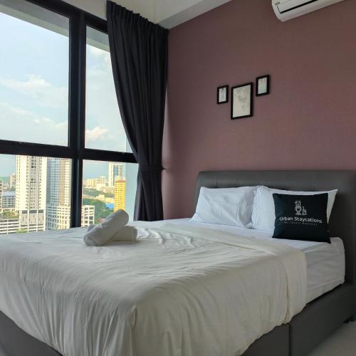 a bedroom with a large bed with a large window at Cozy & Drive Urban Suite by WL in Jelutong