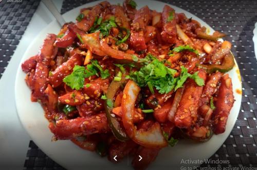 um prato de alimentos com carne e legumes sobre uma mesa em Mauji's Villa Hotel & Guest House em Prayagraj