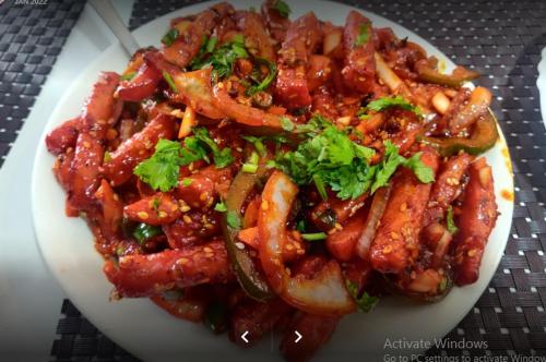 a plate of food with meat and vegetables on a table at Mauji's Villa Hotel & Guest House in Prayagraj