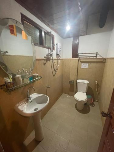 a bathroom with a sink and a toilet and a mirror at Ouis NamKhan Place House in Luang Prabang