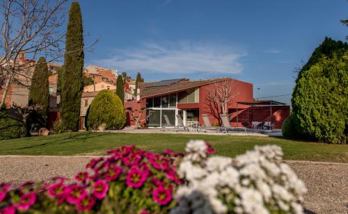 a house with pink flowers in front of it at La Botigueta de Bellmunt in Penellas