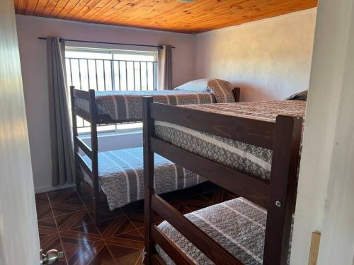 a room with two bunk beds and a window at Casa los cabreras in Quillón