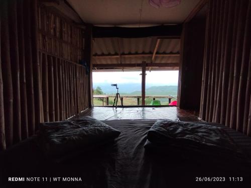 Cette chambre comprend un lit et une grande fenêtre. dans l'établissement ม่อนนาป่าบงเปียง โฮมสเตย์, à Ban Mae Pan Noi