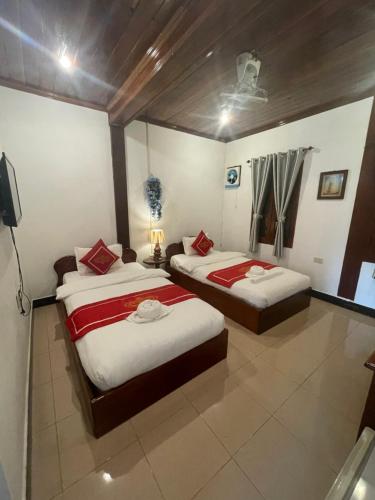 a bedroom with two beds and a television at Luang Prabang - Villa Ouis Namkhan Riverside 2 in Luang Prabang