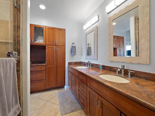 a bathroom with two sinks and a large mirror at Keauhou sea cliff oceanfront hale in Kailua-Kona