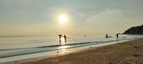 a group of people playing in the water on the beach at Turtle Nest in Khao Tao