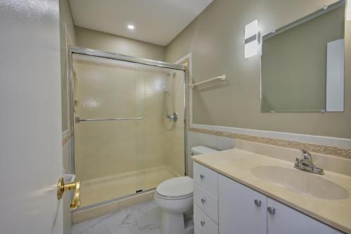 a bathroom with a shower and a toilet and a sink at Beautiful Beachfront Apartment! in Seven Mile Beach