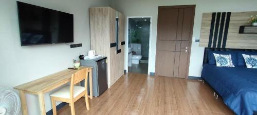a bedroom with a bed and a desk and a television at Turtle Nest in Khao Tao