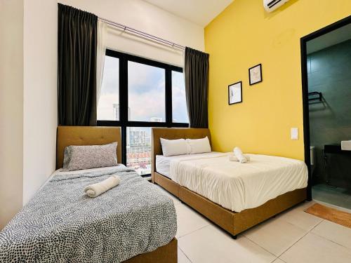 a bedroom with two beds and a window at Cozy & Drive Urban Suite by WL in Jelutong