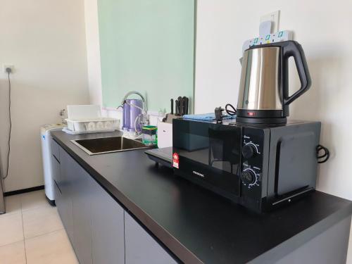 a microwave sitting on a counter in a kitchen at Cozy & Drive Urban Suite by WL in Jelutong