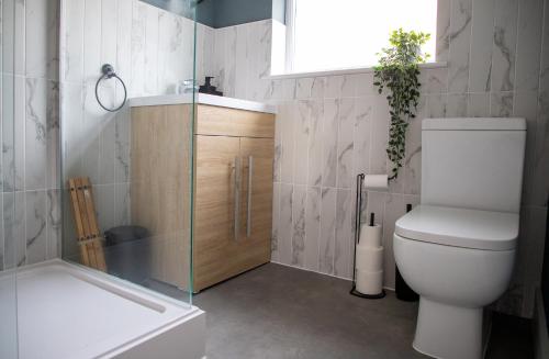 a bathroom with a toilet and a shower and a window at Beach Apartments - 1st Floor Cleveleys in Cleveleys