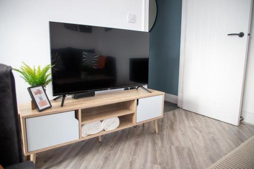 a living room with a tv on a stand at Beach Apartments - 1st Floor Cleveleys in Cleveleys