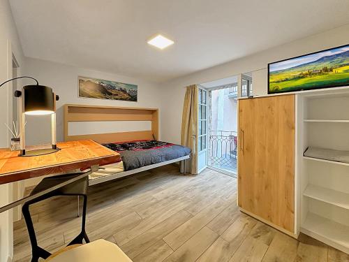 um quarto com uma cama e uma secretária num quarto em Studio 505 - Sion Old City - Swiss Alps em Sião