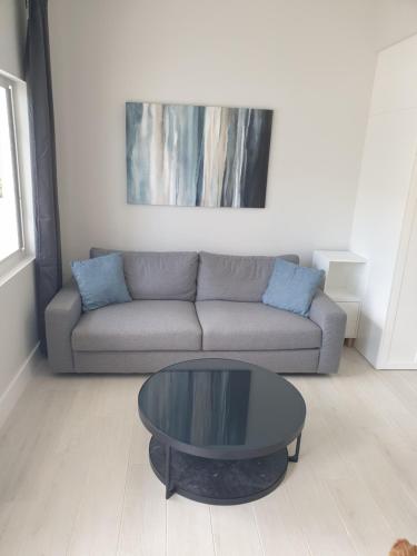 sala de estar con sofá y mesa de cristal en Modern 1 bedroom walking distance to the beach! en West Bay