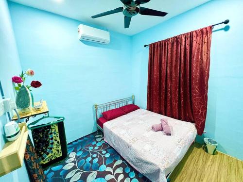 a bedroom with a bed and a ceiling fan at HH Homestay Dungun in Kampong Gok Kapor