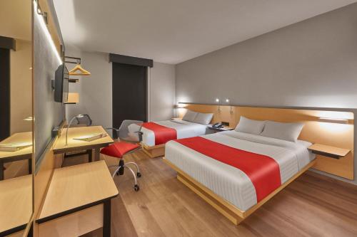 a hotel room with two beds and a desk at City Express Plus by Marriott Ciudad de México Mundo E in Mexico City