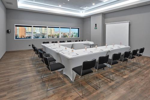 a conference room with a large white table and chairs at City Express Plus by Marriott Ciudad de México Mundo E in Mexico City