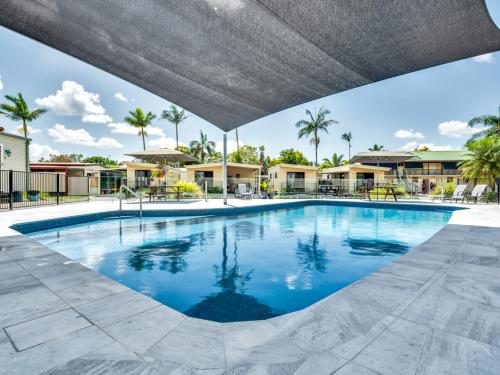 a large swimming pool at a resort with palm trees at Ingenia Holidays Taigum in Brisbane