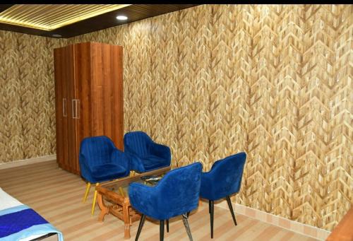 a waiting room with blue chairs and a cabinet at Hotel Pearl Residency in Mukteshwar