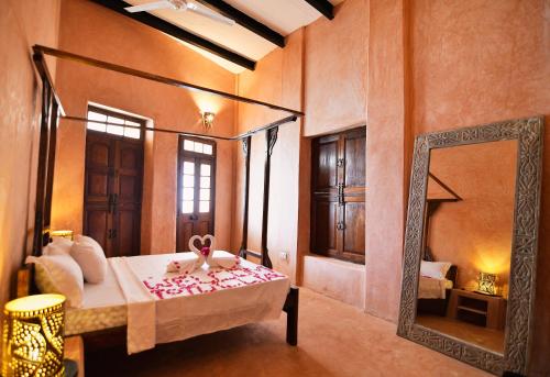 a bedroom with a canopy bed and a mirror at Tulia Old Town in Mombasa