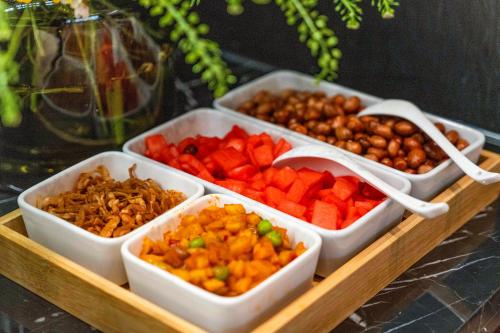 a tray with four trays of different fruits and vegetables at Wuyu Hotel, Jingyun Mountain & Zhuangyuanbei Light Rail Station in Beibei District in Chongqing