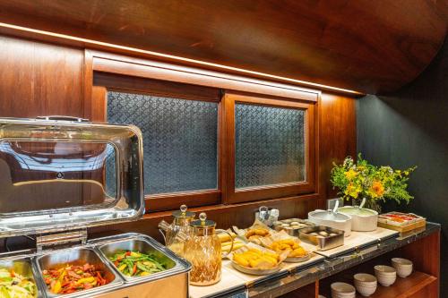 a kitchen with a buffet of food on a counter at Wuyu Hotel, Jingyun Mountain & Zhuangyuanbei Light Rail Station in Beibei District in Chongqing