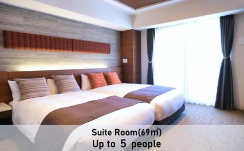 1 dormitorio con 2 camas y ventana grande en LUXCARE HOTEL, en Osaka
