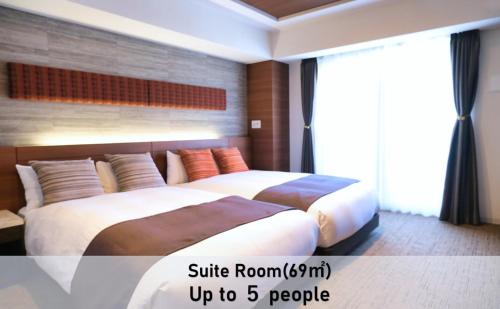 a bedroom with two beds and a large window at LUXCARE HOTEL in Osaka