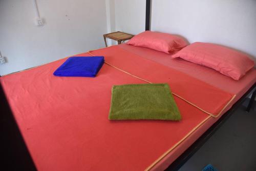 uma grande cama vermelha com duas almofadas em Big Head Bungalows em Koh Rong Sanloem