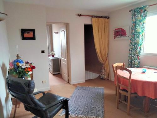 a living room with a table and a chair at Chambre à louer chez l'habitant in Payré