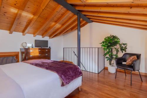 1 dormitorio con 1 cama y 1 silla en [Marostica - Villa with Swimming Pool] Netflix - WiFi en Sarcedo