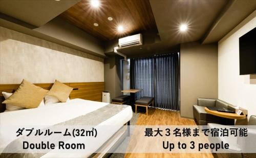 大阪市にあるTAKUTO HOTEL 心斎橋のベッドとテーブルが備わるホテルルームです。