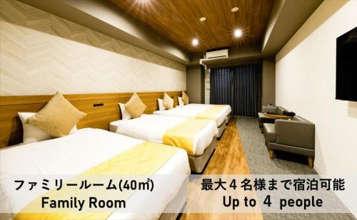 大阪市にあるTAKUTO HOTEL 心斎橋のベッド3台とテレビが備わるホテルルームです。