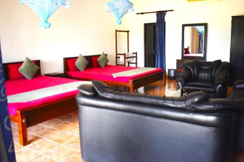 a living room with a bed and a couch at Thalladi Holiday Bungalow in Mannar