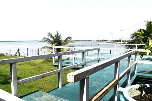 a bridge over a body of water with palm trees at Thalladi Holiday Bungalow in Mannar