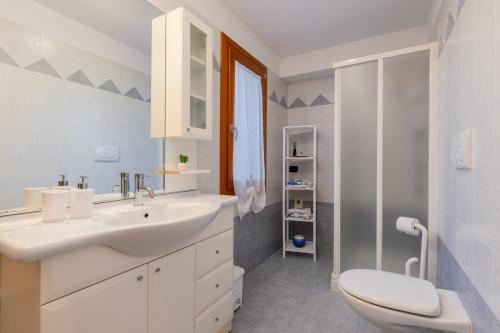 een witte badkamer met een wastafel en een toilet bij [Marostica - Villa with Swimming Pool] Netflix - WiFi in Sarcedo